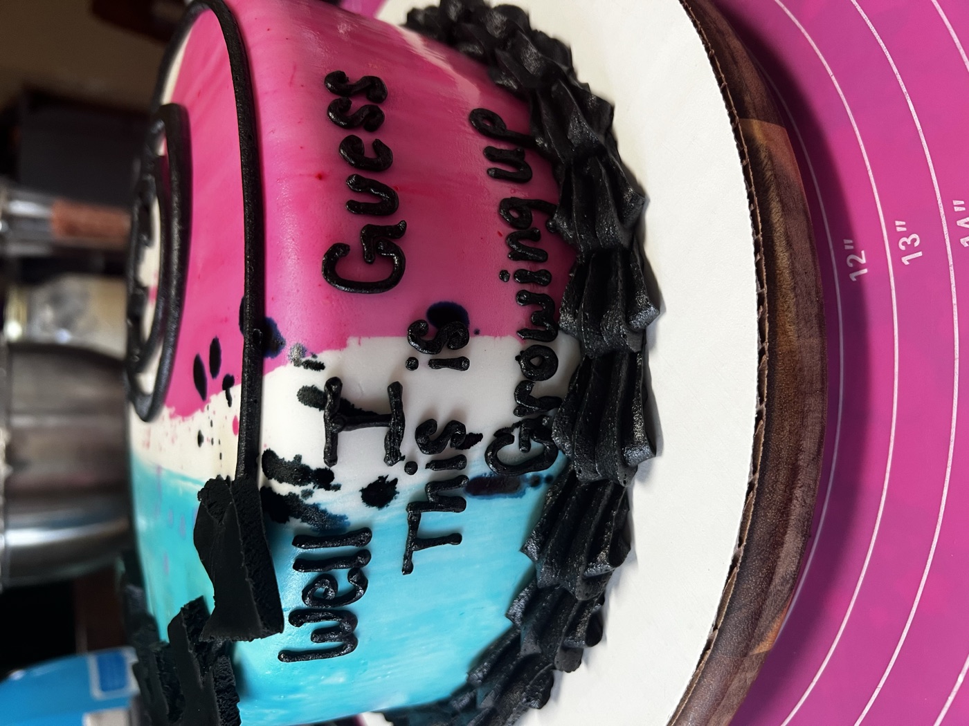 Custom birthday cake iced in teal, white and pink with black piped lettering and a black shell border
